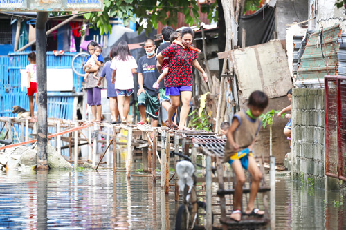 台風13号(比名ジョリーナ)による大雨で冠水した低所得者層の居住地=10日、首都圏モンテンルパ市(EPA=時事)