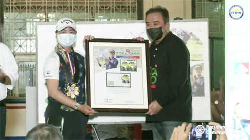 マニラ中央郵便局で行われた発売記念式典に参加した笹生選手(左)とフルジェンシオ郵政公社総裁=22日、比郵政公社フェイスブックでのLive配信より