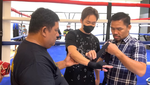 朝倉の拳にバンテージを巻くパッキャオ。左はトレーナーのブブイ氏=朝倉未来ユーチューブチャンネルより