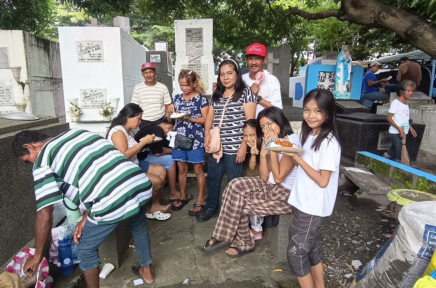 他人の墓でくつろぐアドビンクラ家=1日午後、首都圏マカティ市の南部墓地で竹下友章撮影