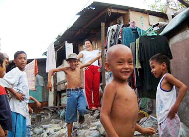 パサイ市にある自宅前に立つハナコさん(中央の女性)。父は日本人男性で、自身も日本人との間に3人の子供を産んだという