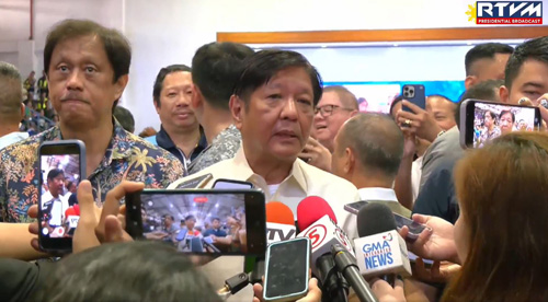 記者団の囲み取材に応じるマルコス大統領=22日、パンガシナン州リンガエン町(大統領府公表)